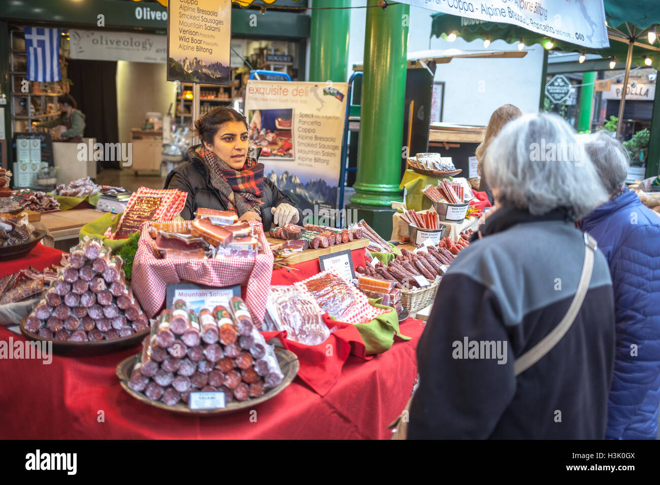 Borough Market, Londra UK donna giovane venditore di parlare con donna anziana Foto Stock