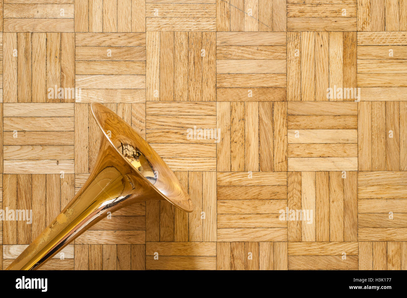 Trombone bell il marrone parquet in legno, strumento a fiato la musica jazz e il simbolo dello spazio di copia Foto Stock