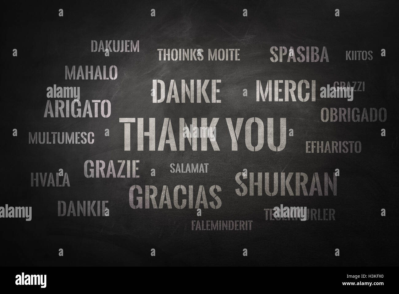 Ringrazio nuvola di parole scritte in molte lingue diverse su una lavagna Foto Stock