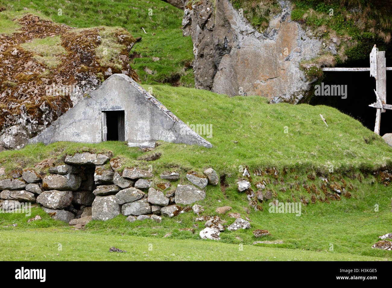 Abbandonato coperto di tappeto erboso islandese casa ora utilizzato come campo store Islanda Foto Stock
