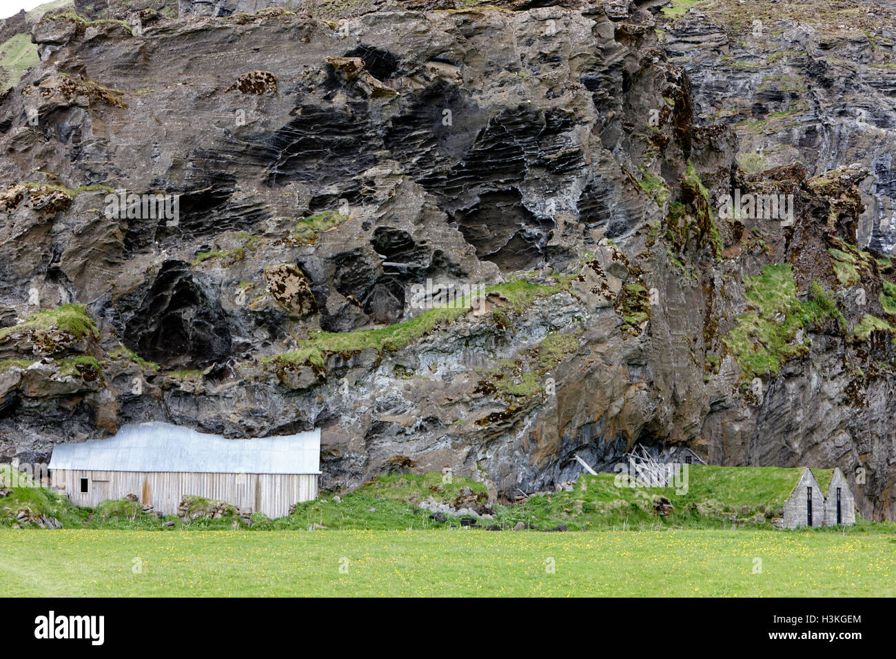 Abbandonato coperto di tappeto erboso islandese ospita ora utilizzato come campo store e stalla costruita nella roccia Islanda Foto Stock