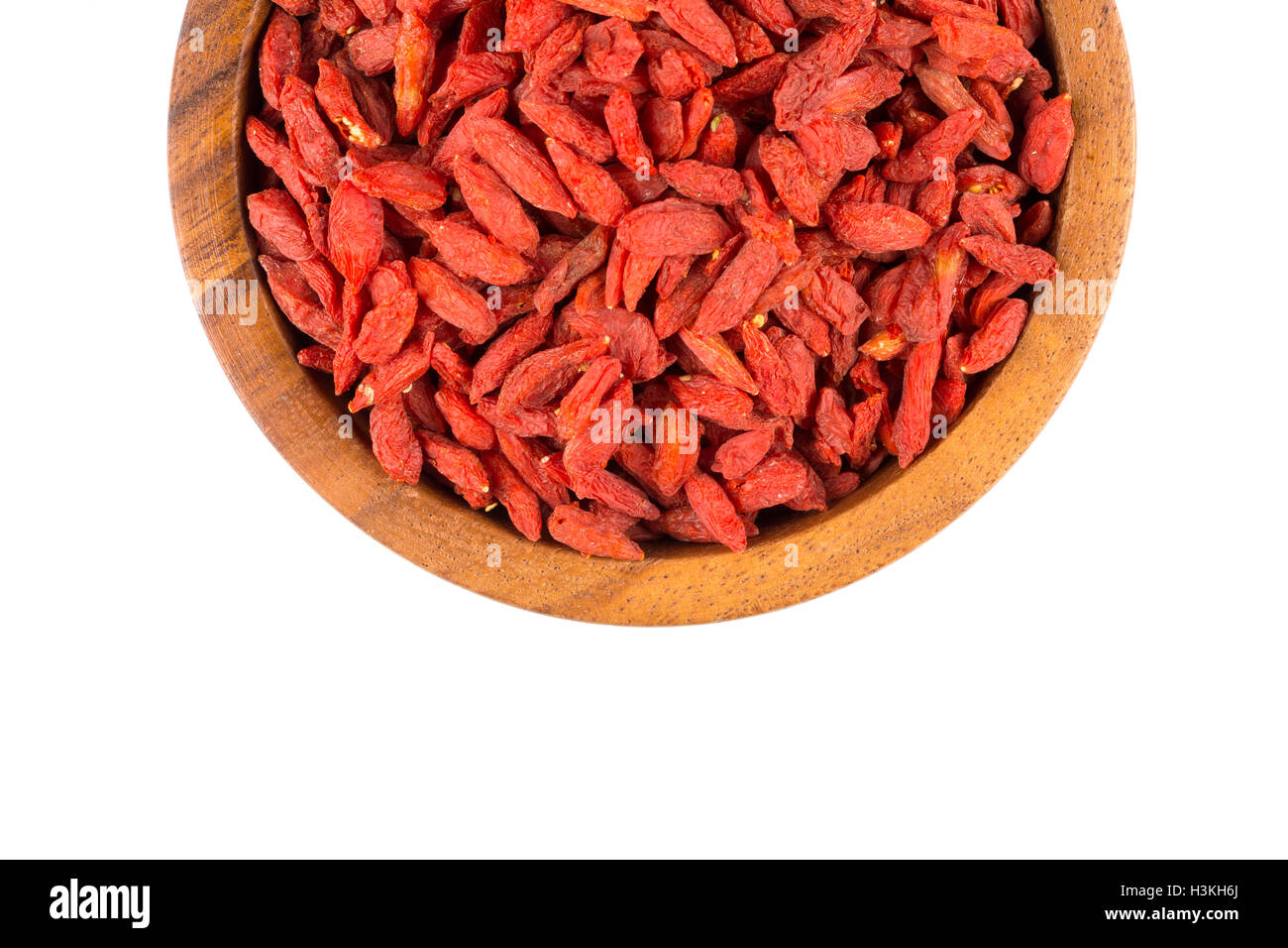 Cinese bacche di goji nella ciotola di legno vicino su sfondo bianco Foto Stock