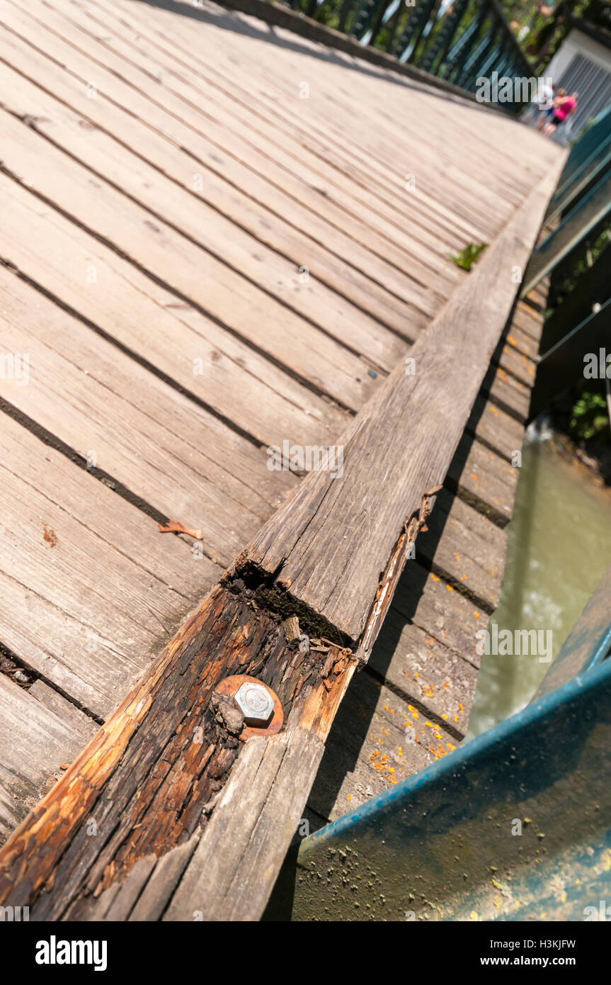 Ampio angolo di vista obliqua di una passerella di legno attraverso il Passirio Merano, Fiume travi danneggiate in primo piano. Foto Stock