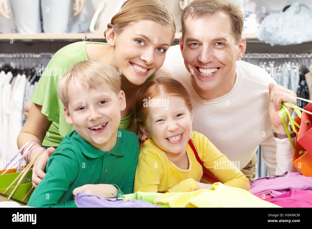 Ritratto di una famiglia di quattro persone nel negozio guardando la fotocamera e sorridente Foto Stock