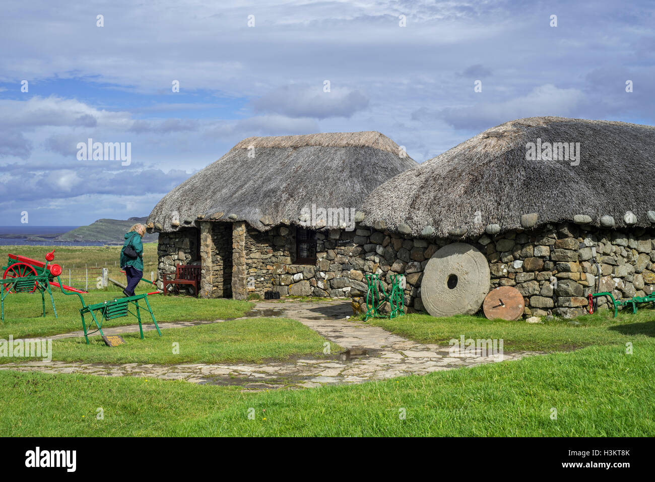 Turisti in visita in cottage con il tetto di paglia a Skye Museo di Vita sull'isola, Kilmuir, Isola di Skye in Scozia Foto Stock