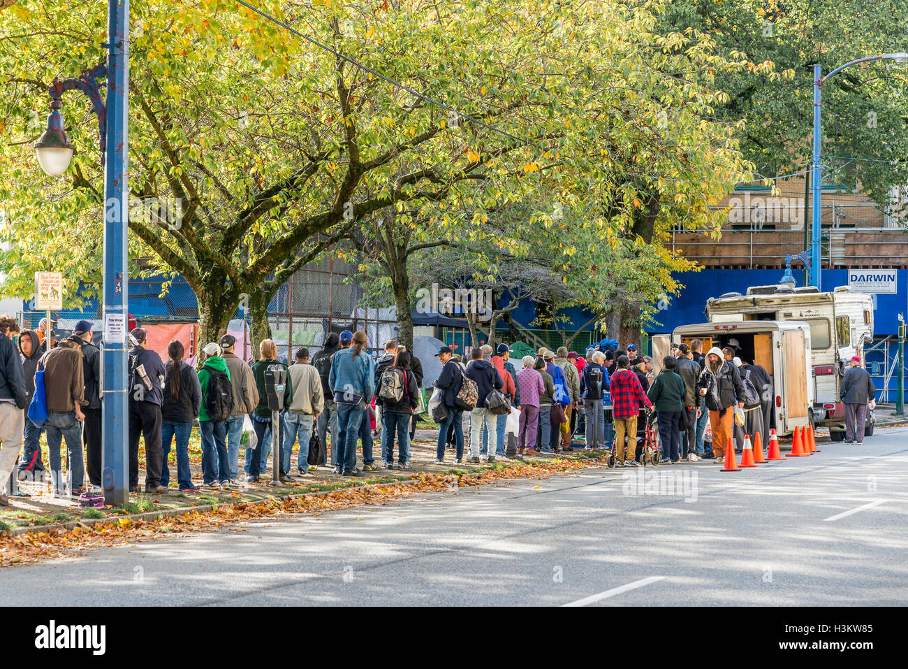 Persone in Canada più poveri del quartiere line up per cibo gratuito, Powell Street, Vancouver, British Columbia, Canada. Foto Stock