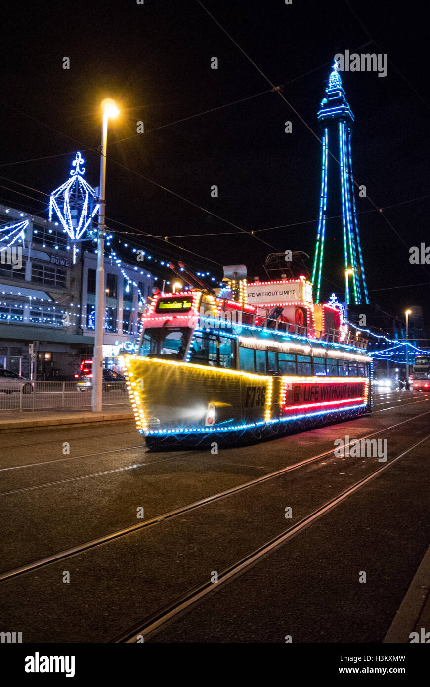 Un tram decorata come una barca durante le luminarie di Blackpool con la Blackpool Tower in background Foto Stock
