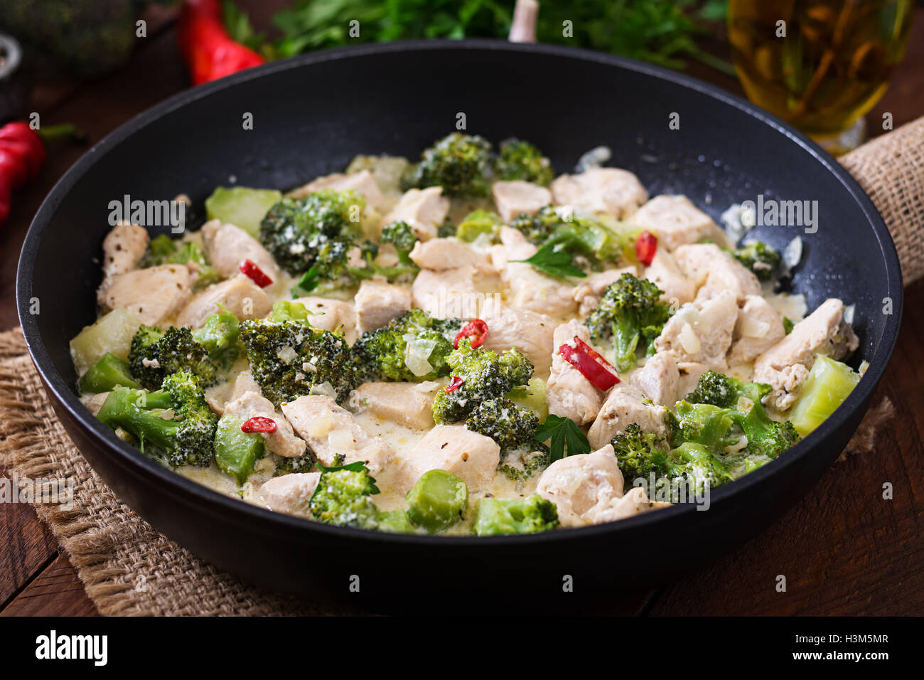 Delicato Saltare il pollo con broccoli e peperoncino in una cremosa salsa di aglio Foto Stock