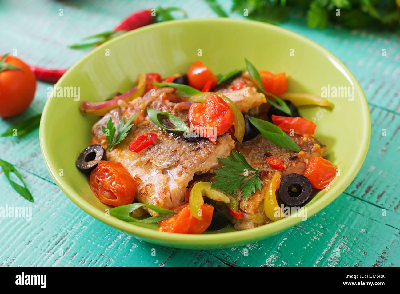 Nasello fritto di filetto con pomodoro e olive in stile mediterraneo Foto Stock