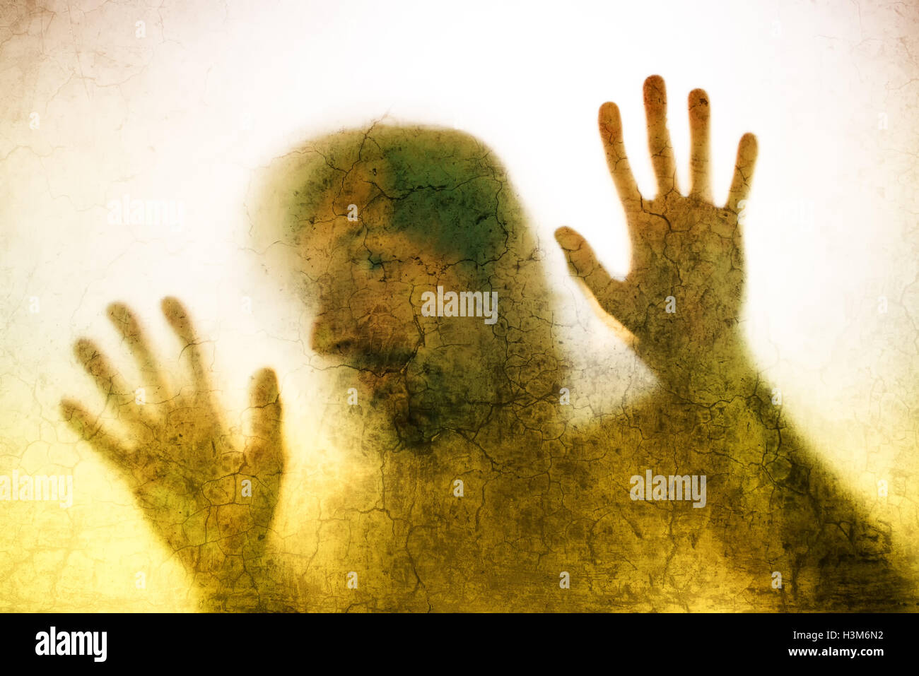 Uomo intrappolato concetto con back lit silhouette di mani dietro il vetro opaco, utili come immagine illustrativa per il traffico di esseri umani, pr Foto Stock