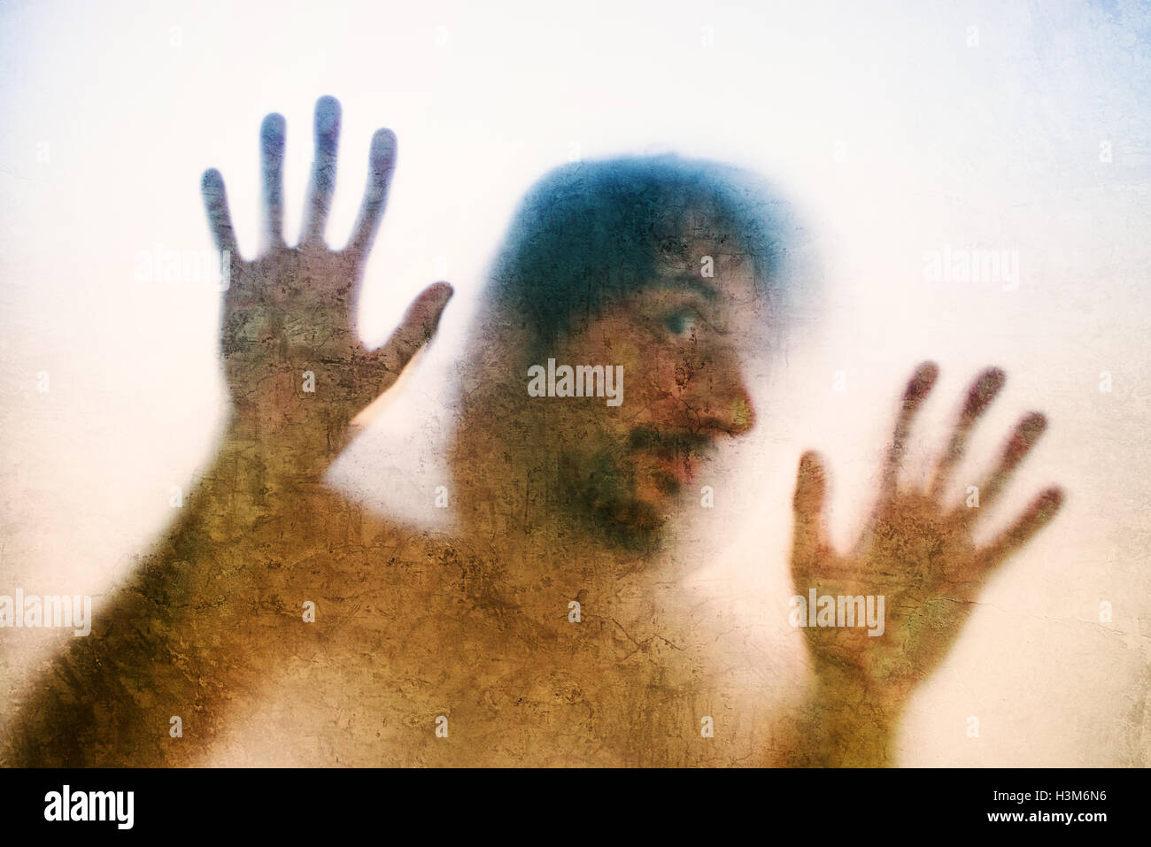 Uomo intrappolato concetto con back lit silhouette di mani dietro il vetro opaco, utili come immagine illustrativa per il traffico di esseri umani, pr Foto Stock