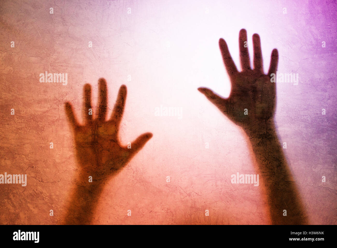 Catturato persona di sesso femminile concetto con back lit silhouette di mani dietro il vetro opaco, utili come immagine illustrativa per traf umana Foto Stock