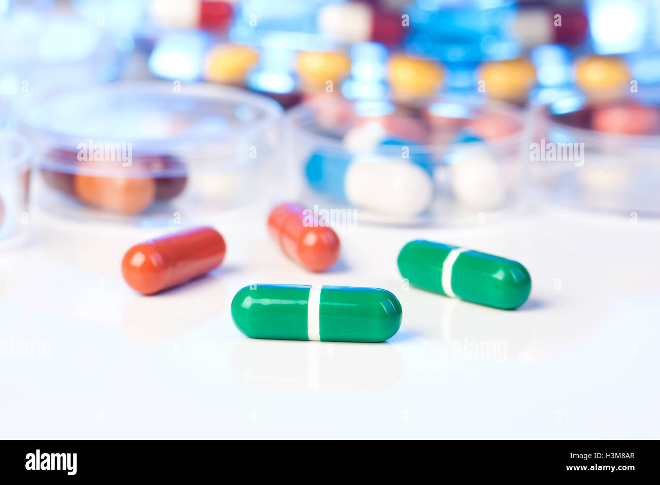 Close up di pillole di verde su sfondo bianco Foto Stock