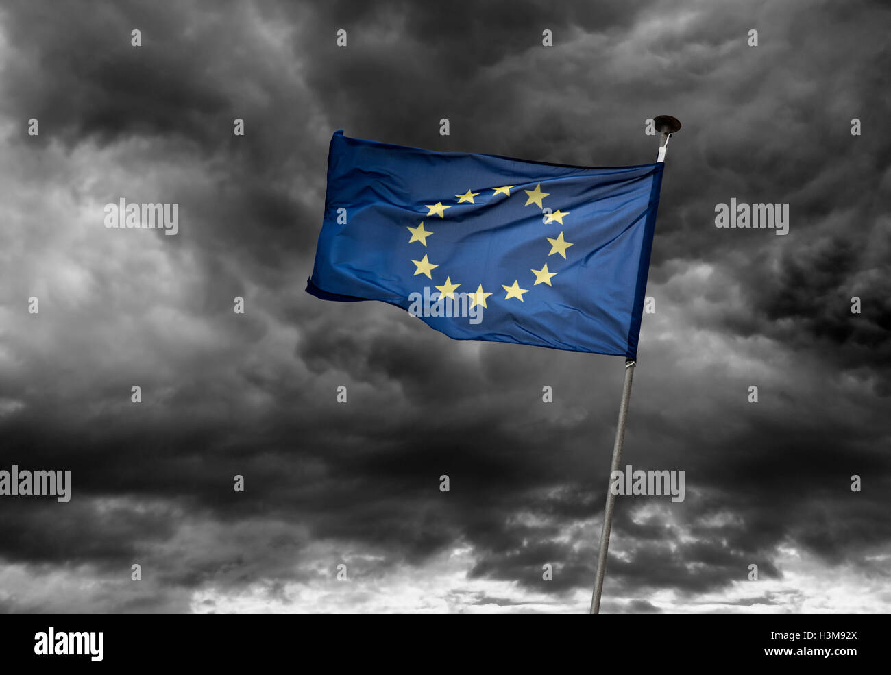 Una bandiera europea sventola contro un cielo nuvoloso scuro nel vento. Foto Stock