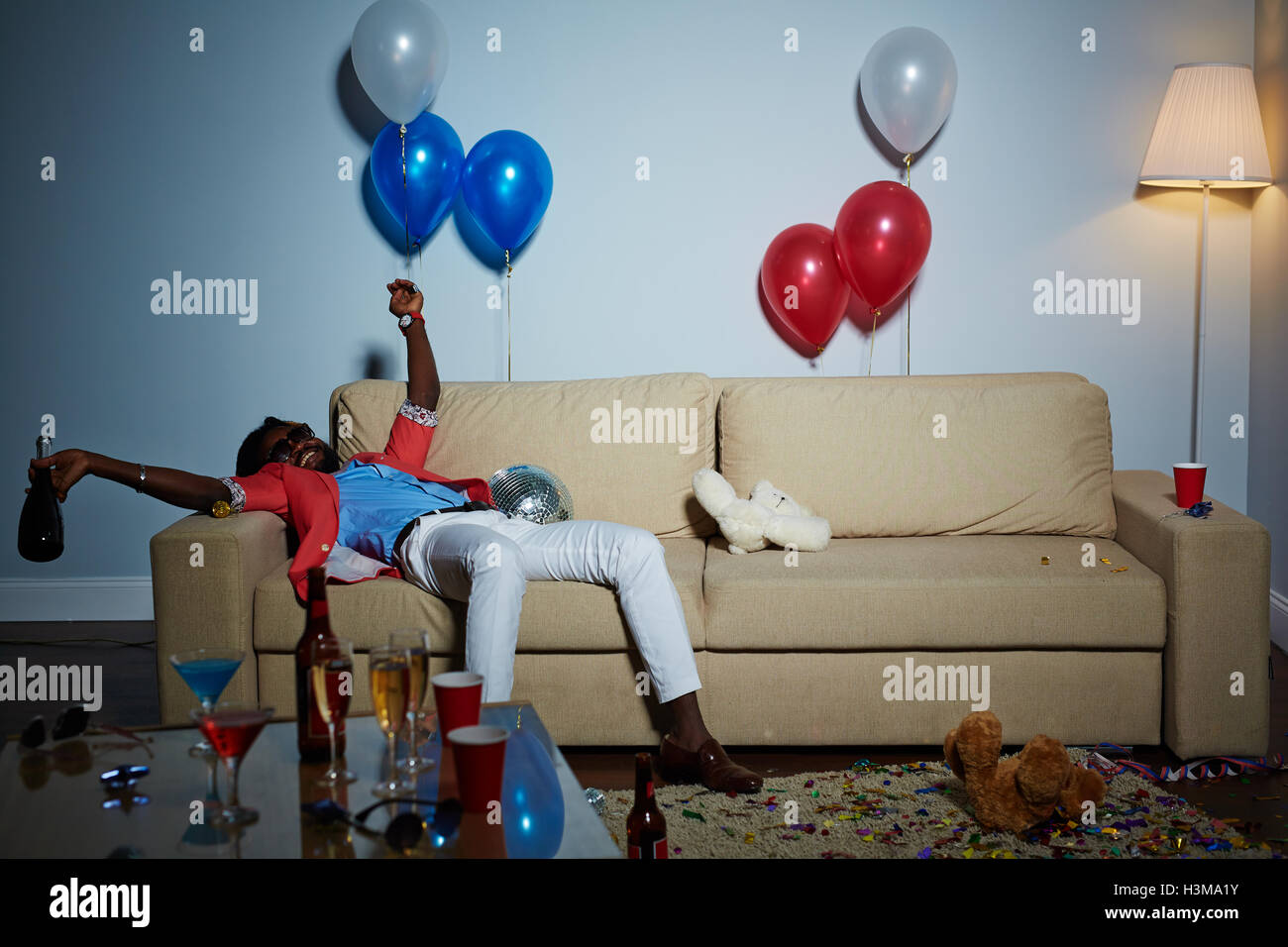Guy rilassato con bottiglia sdraiato sul divano Foto Stock