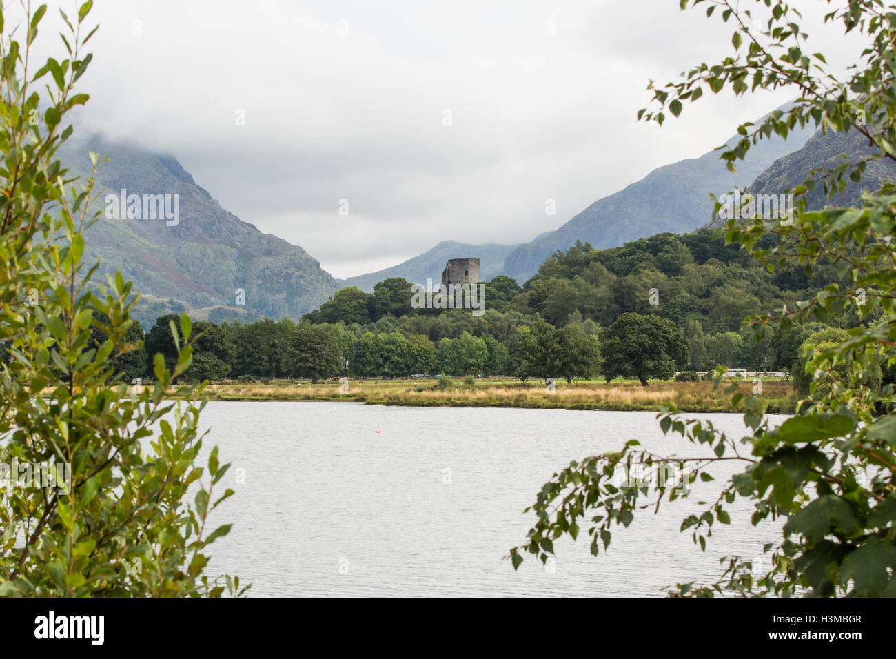 Il castello di Dolbadarn attraverso Lyn Padarn con Llanberis passare oltre Foto Stock