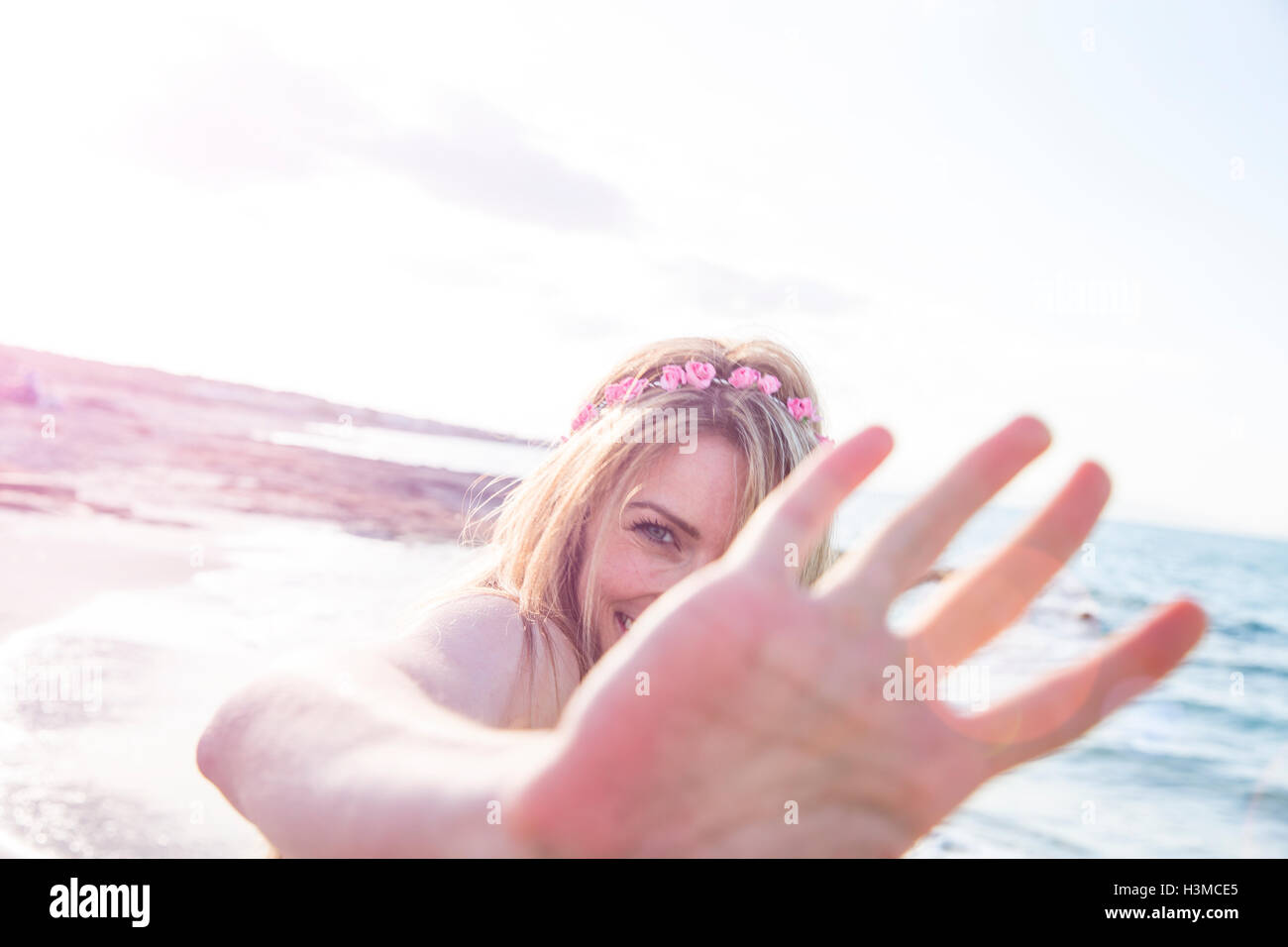 Donna che ricopre la faccia sulla spiaggia Foto Stock