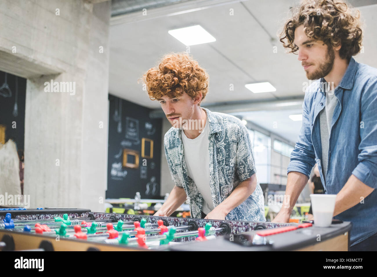 Co-lavoratori a giocare a biliardino a rottura Foto Stock