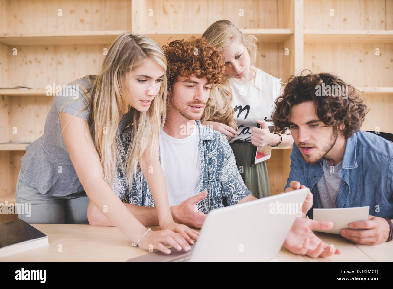 Co-lavoratori che operano sul computer portatile in ufficio Foto Stock