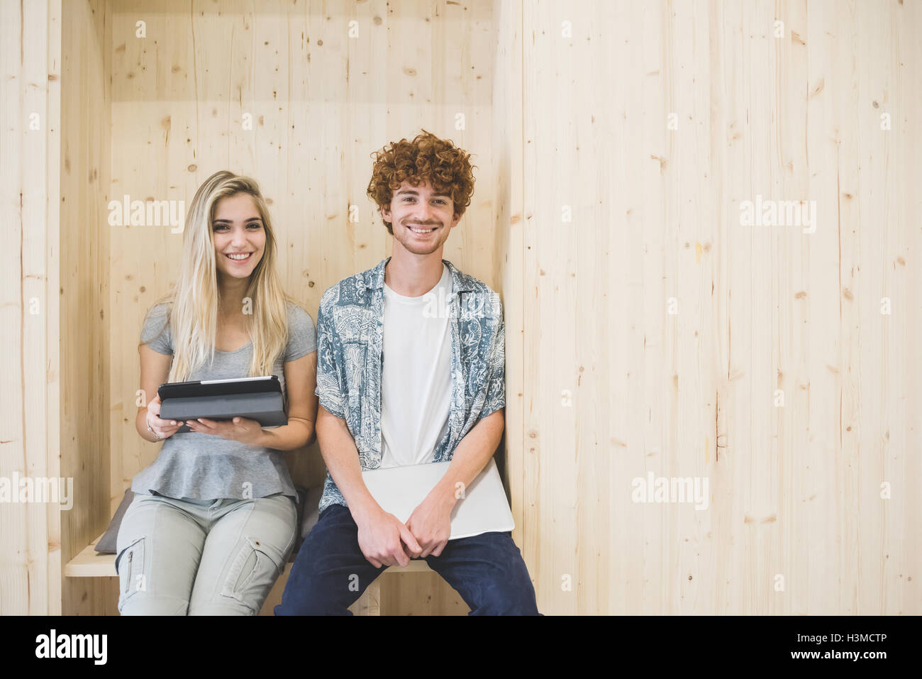 Collaboratori utilizzando digitale compressa in pannelli di legno area con posti a sedere Foto Stock