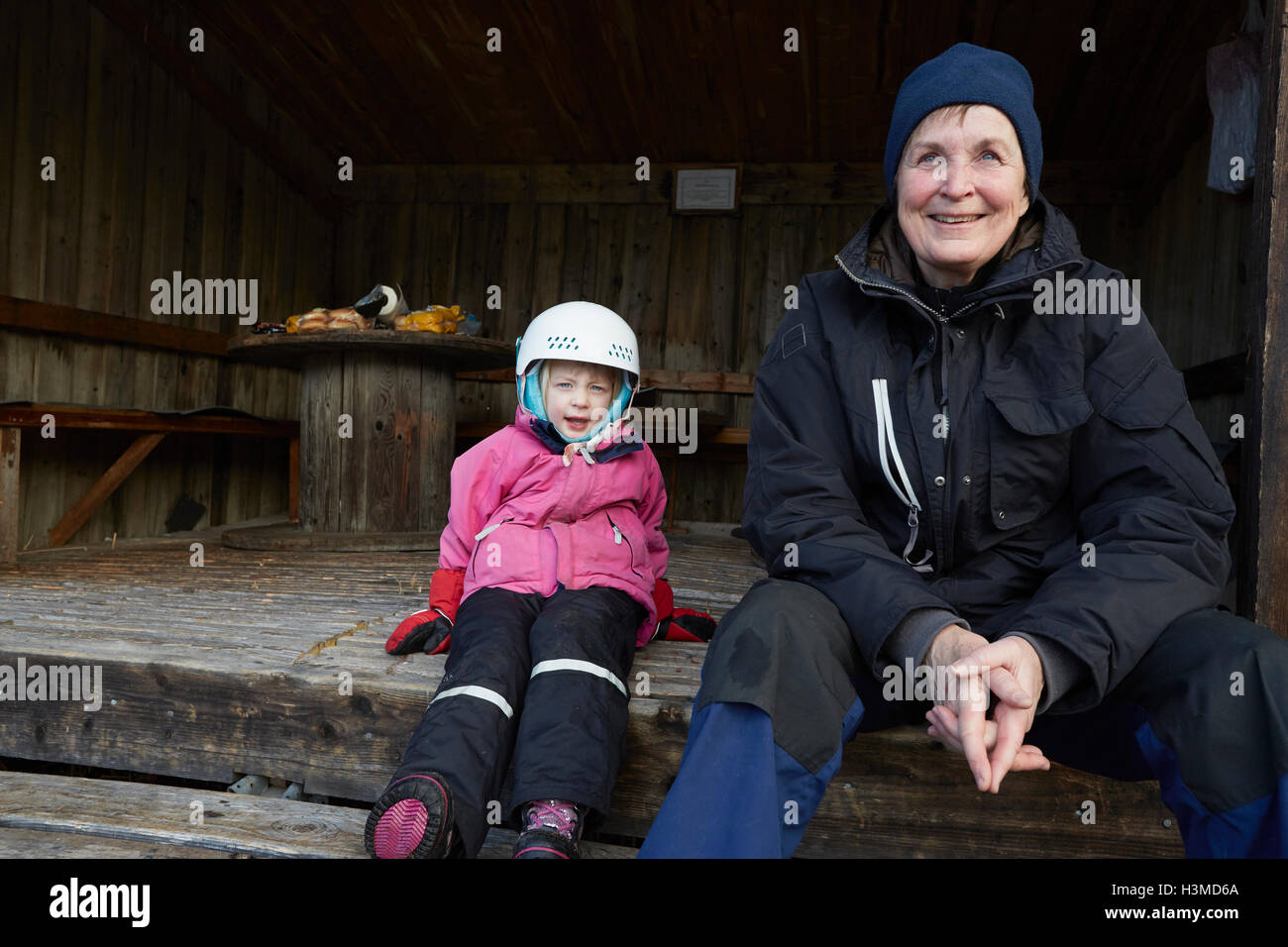 Ragazza che indossa il casco sci seduta sul passo del granaio con la nonna, Gavle, Svezia Foto Stock