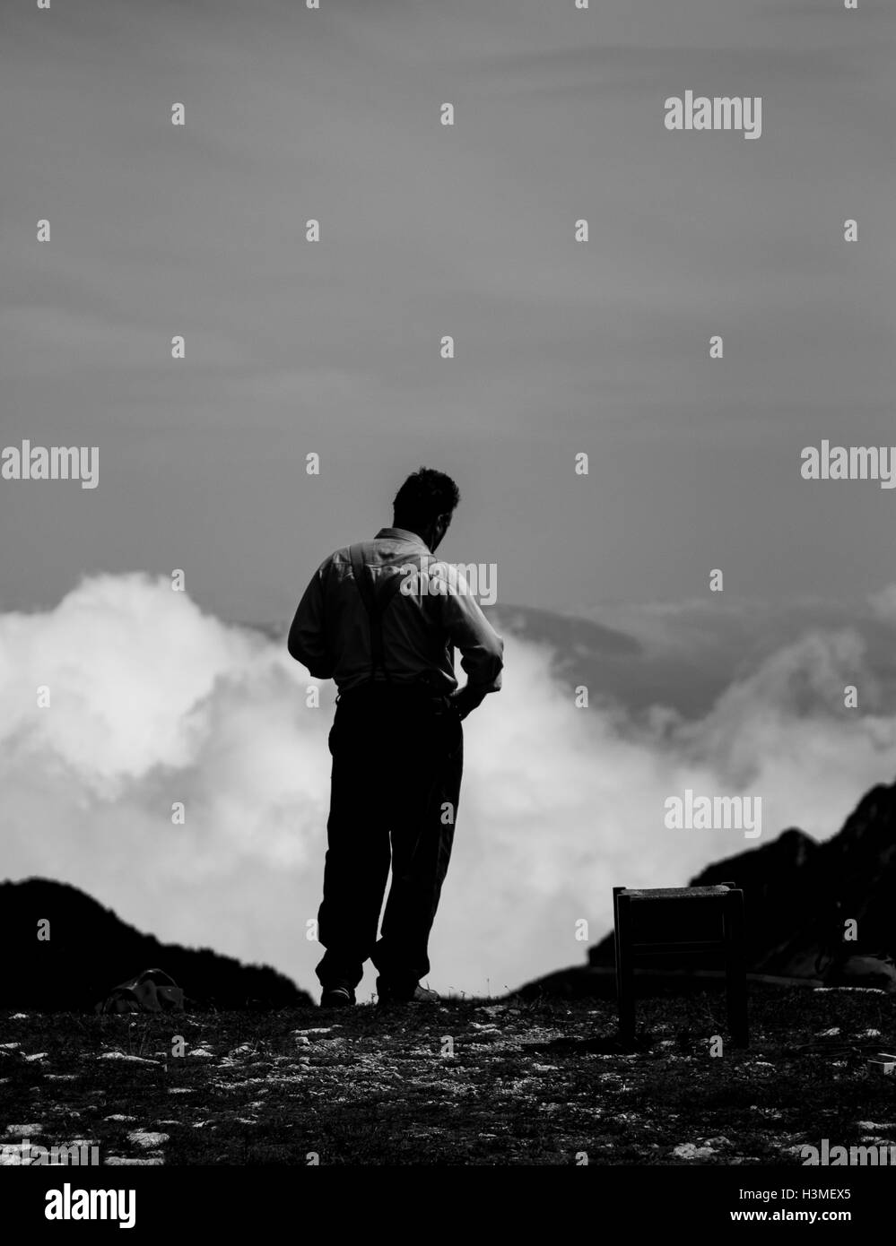 Un uomo che guarda da una montagna il panorama Foto Stock