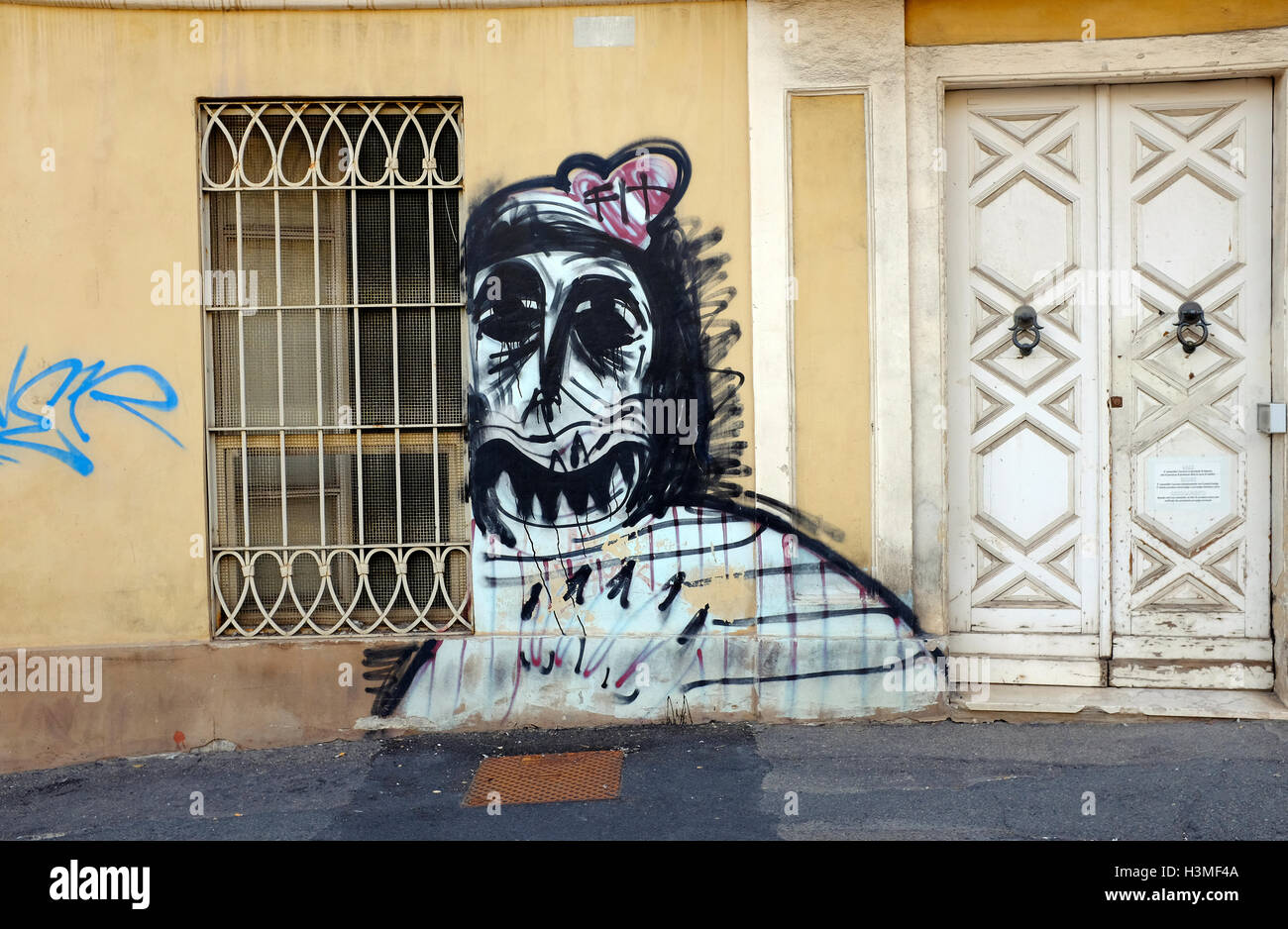 Macabra grafitti stile sulla faccia della parete edilizia, Cagliari, Sardegna, Italia Foto Stock