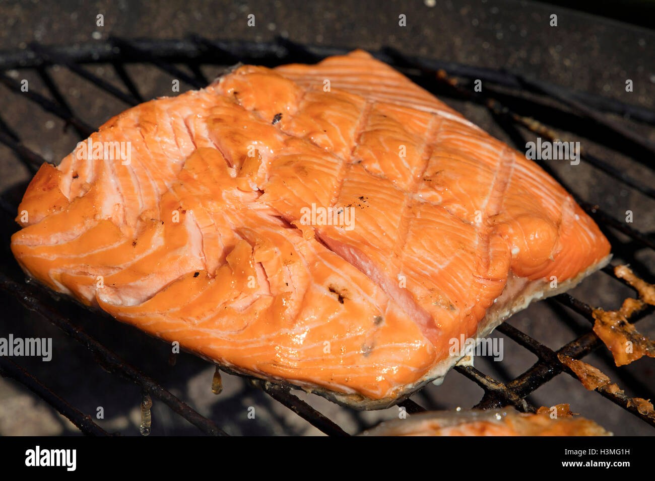 Un salmone alla griglia filetto di pesce barbecue preparato di cottura sulla griglia per il barbecue, close up Foto Stock