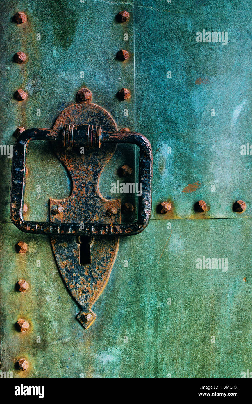 Vecchio rustico di rame metallico porta castello con grandi respingente, weathered texture di superficie Foto Stock