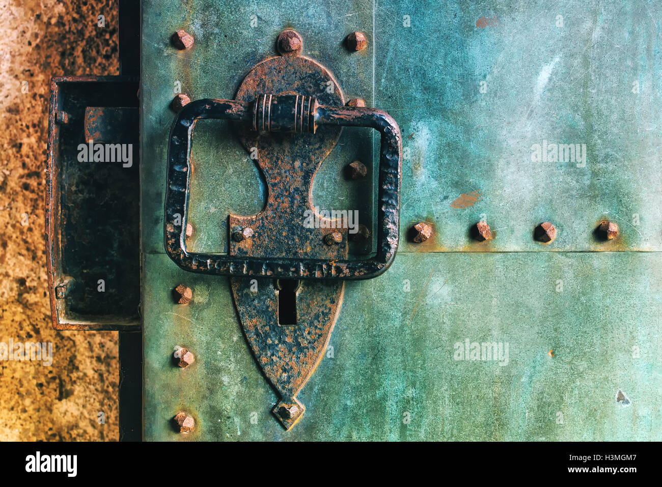 Vecchio rustico di rame metallico porta castello con grandi respingente, weathered texture di superficie Foto Stock