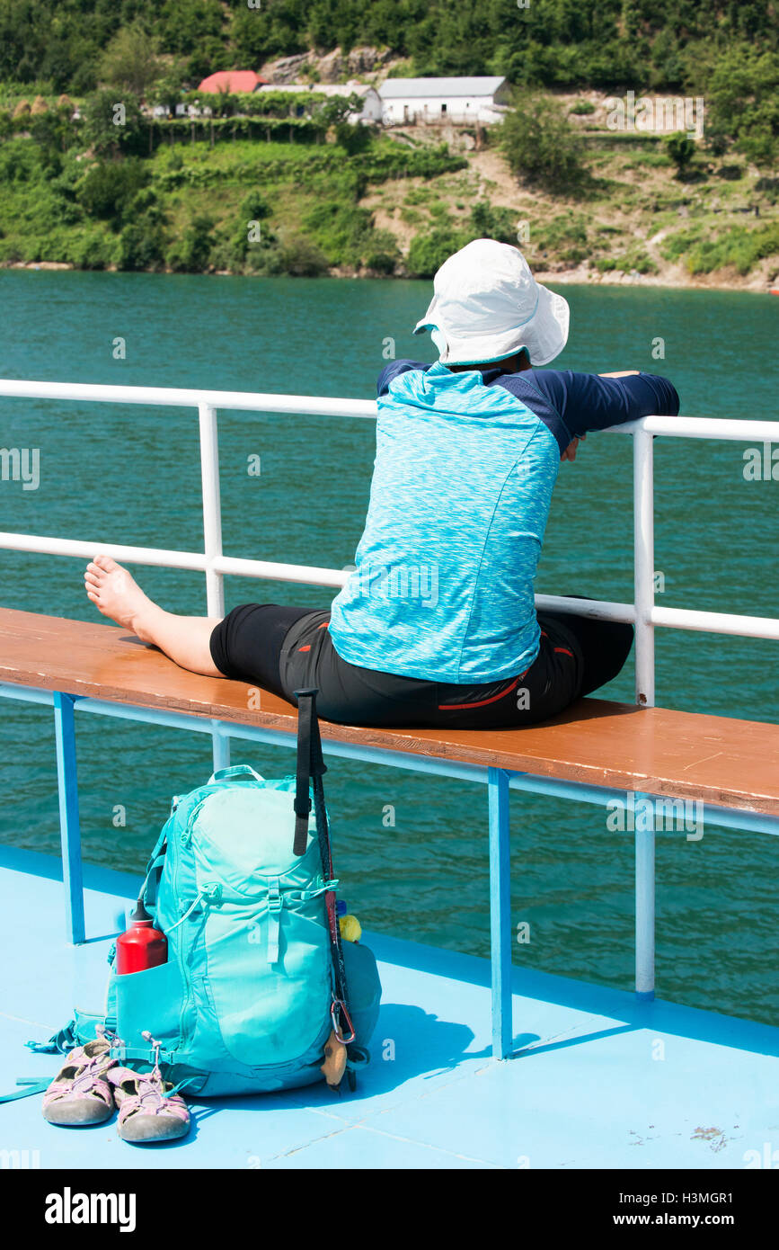 Giovani femmine backpacker si rilassa su un traghetto sul Lago Koman, talvolta descritta come uno dei più grandi del mondo. gite in barca. Foto Stock
