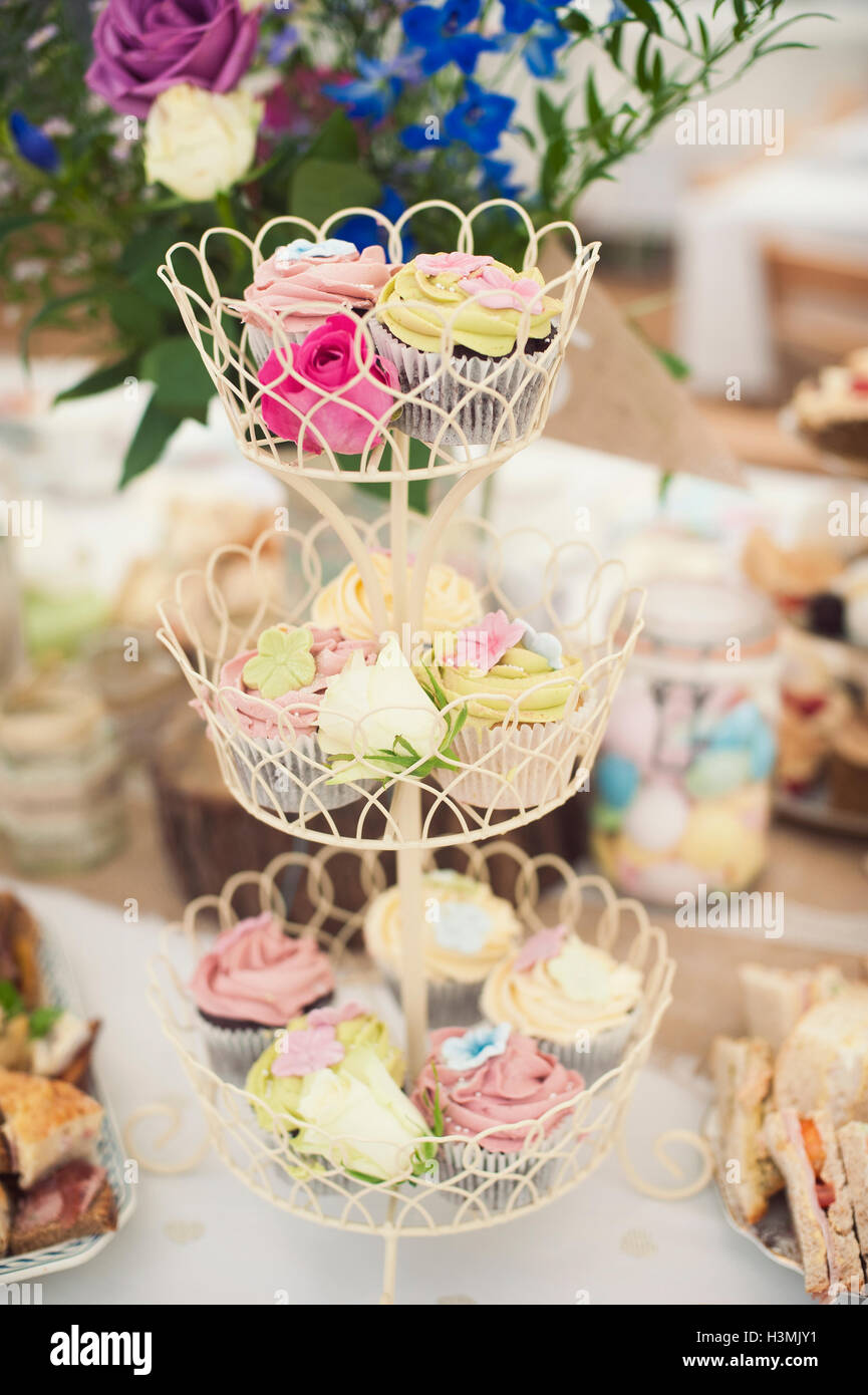 Bello e colorato tortine su un multi-tiered cake stand Foto Stock