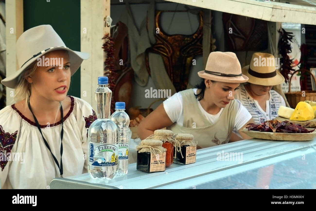 Le ragazze la vendita di carne e salumi, formaggio e preserva da un mercato di Bucarest stallo. Foto Stock