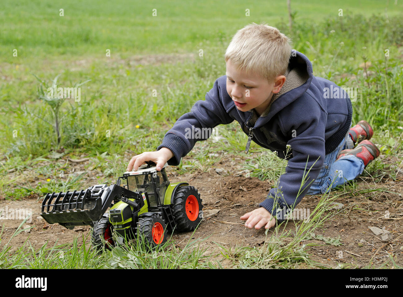 Little Boy giocando con il trattore giocattolo Foto Stock
