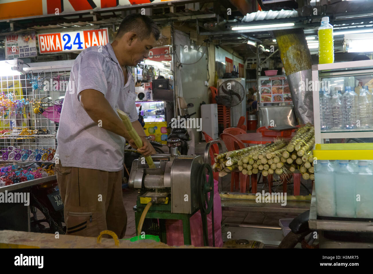 Un uomo estratti da zucchero greggio di canna da zucchero,Jalan Alor,Kuala Lumpur, Malesia Foto Stock