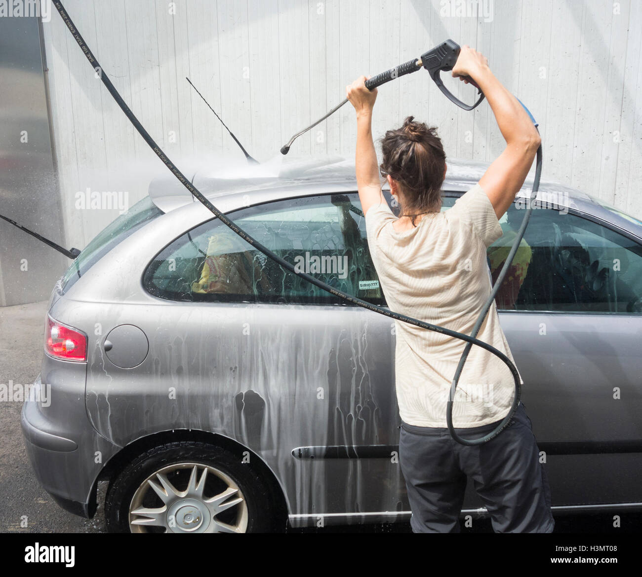 Donna auto lavaggio con idropulitrice a pressione Foto stock - Alamy
