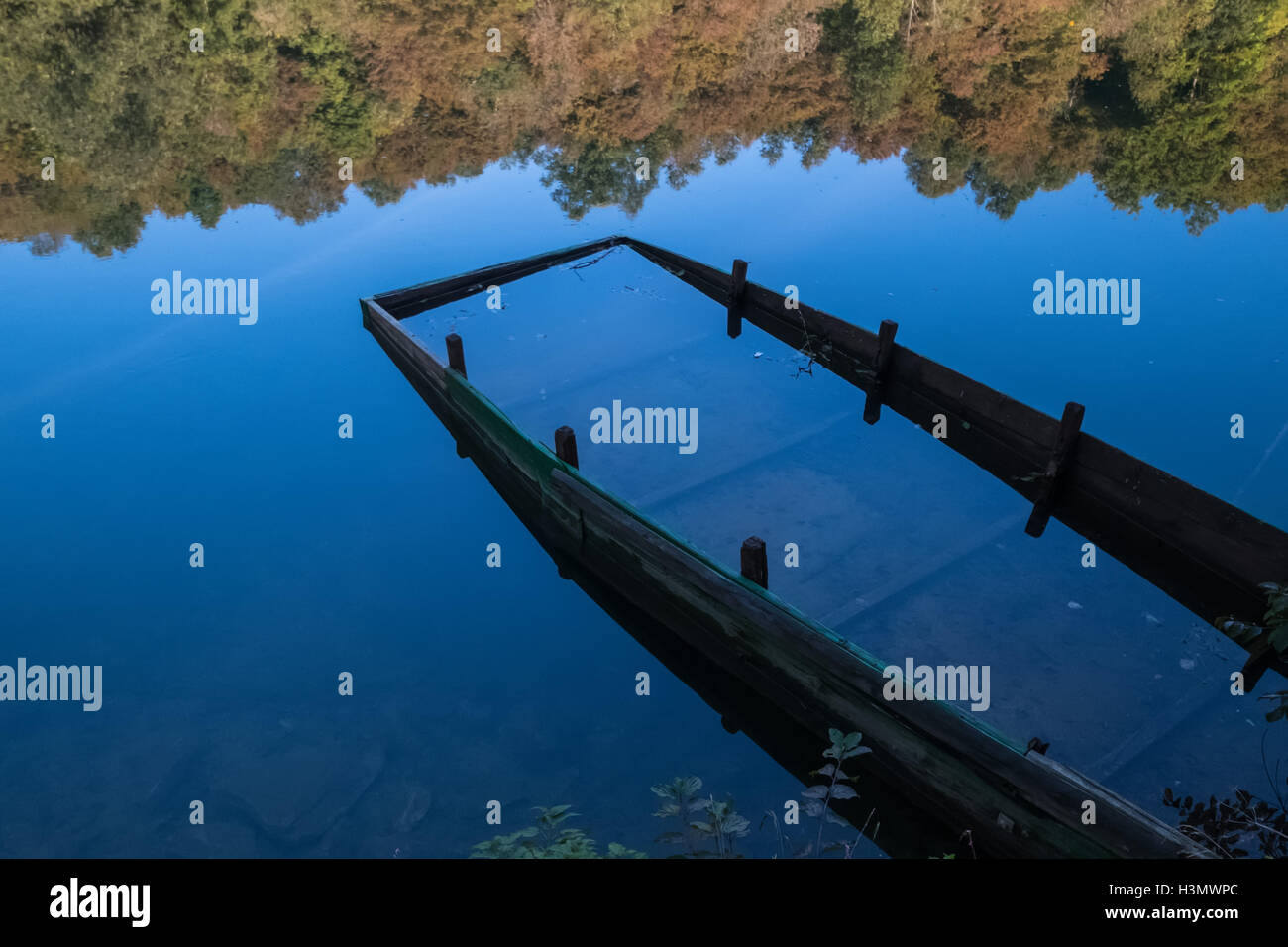 Naufragio di una barca a riva del fiume in una giornata di sole Foto Stock