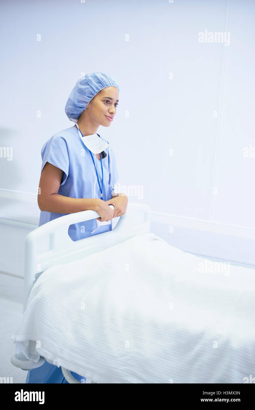 Infermiera femmina in piedi accanto al letto di ospedale Foto Stock