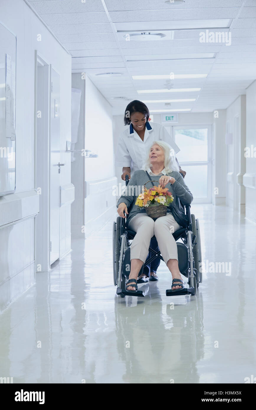 Ospedale di spinta ordinata senior paziente femmina in carrozzella Foto Stock