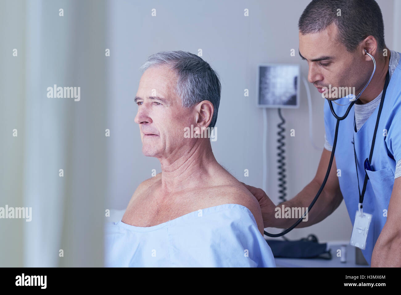 Infermiere ascoltando senior paziente di sesso maschile torna con uno stetoscopio Foto Stock