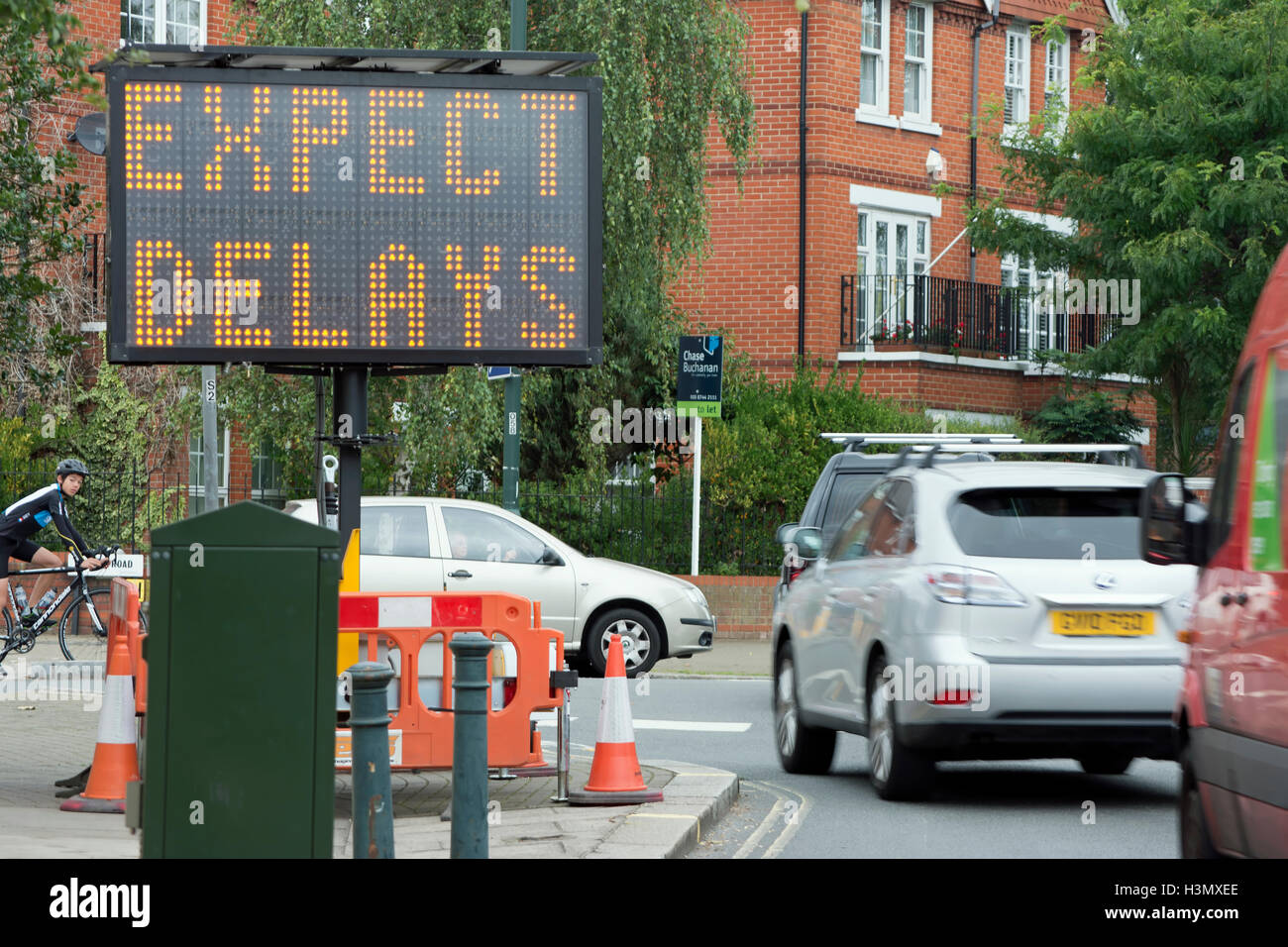 Aspettiamo temporanei ritardi segno in corrispondenza di un incrocio stradale a Twickenham, middlesex, Inghilterra Foto Stock