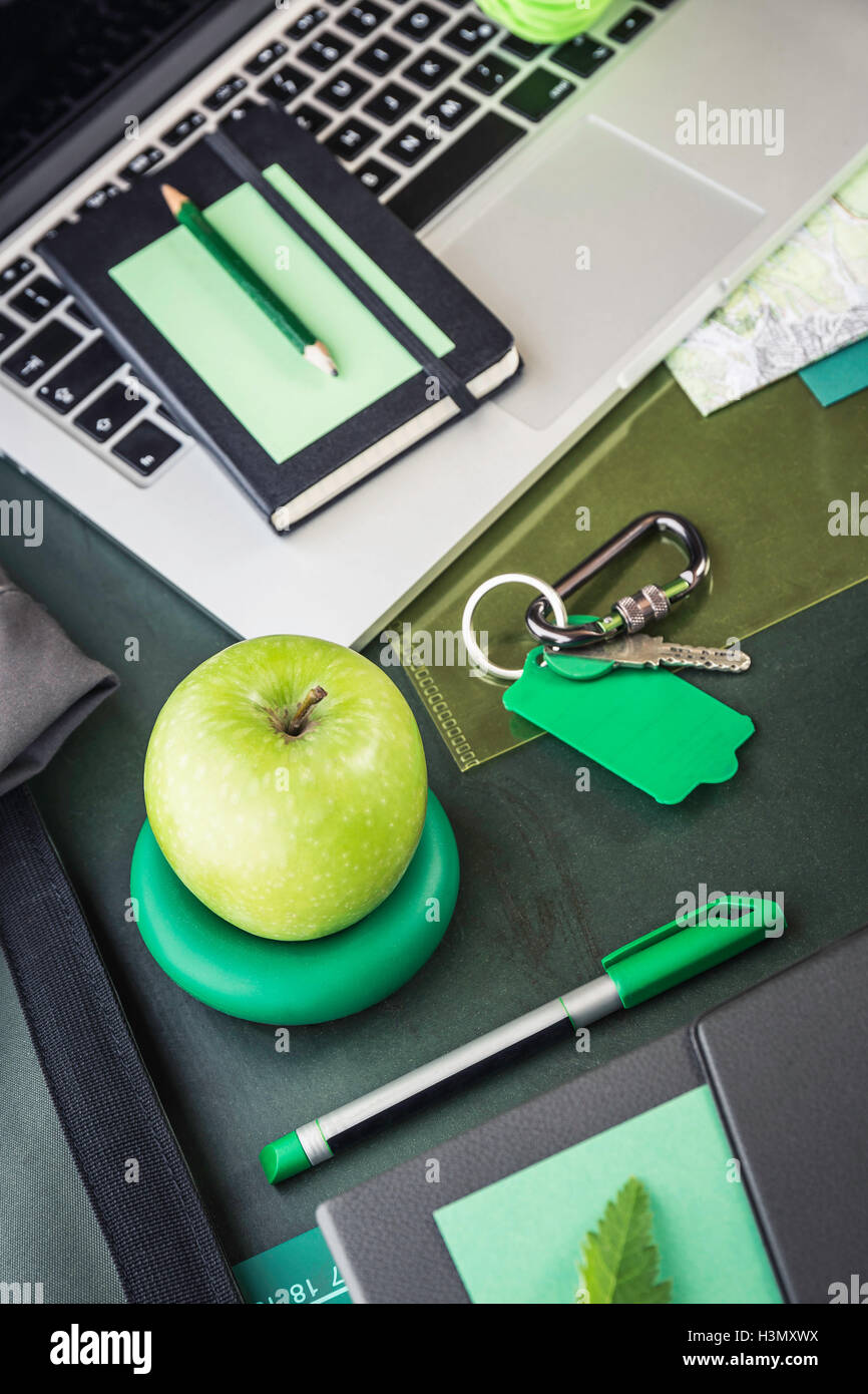 Laptop, notebook, mappa di piegatura e mela verde sul tavolo Foto Stock