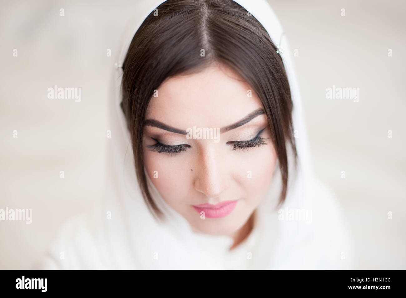 Bella giovane donna in un bianco hijab chiuse gli occhi Foto Stock