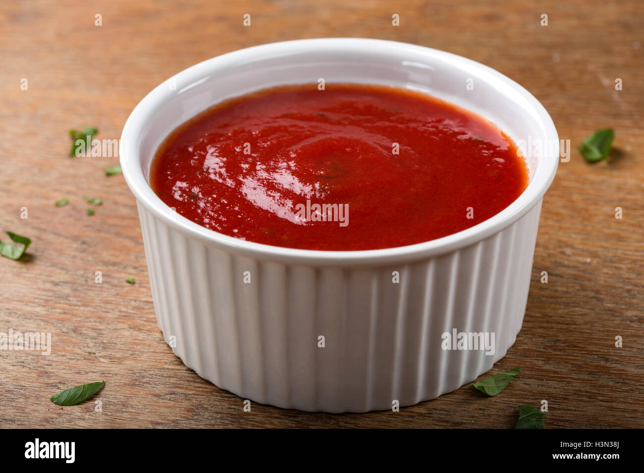 Ciotola con salsa di pomodoro o ketchup su sfondo di legno Foto Stock
