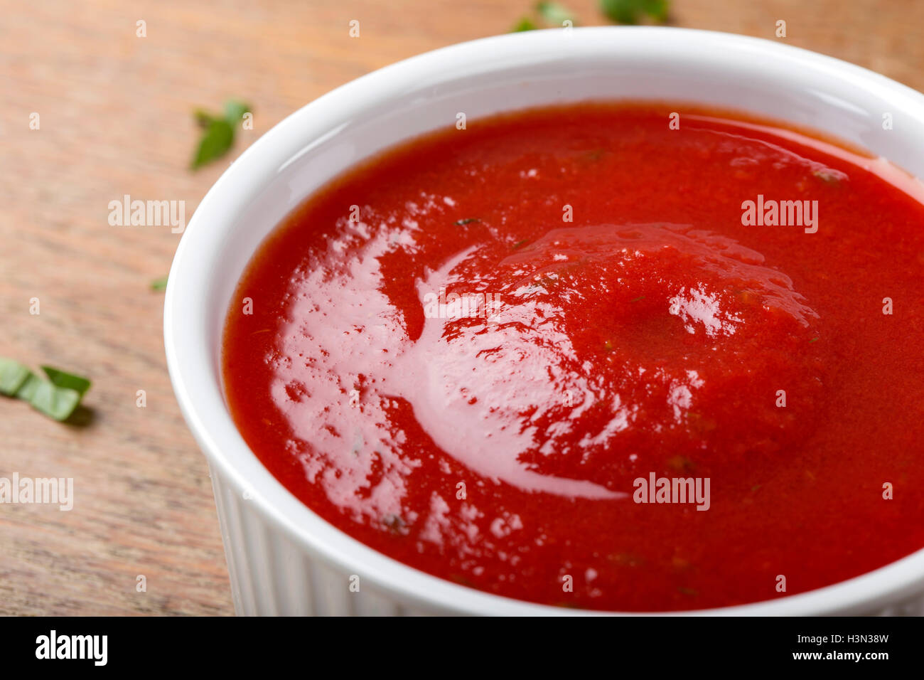 Ciotola con salsa di pomodoro o ketchup su sfondo di legno Foto Stock