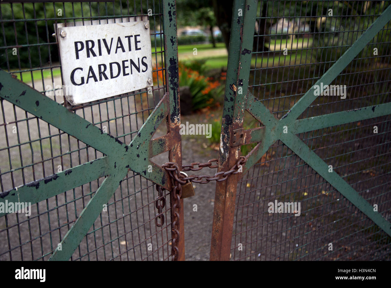 Giardini privati di un cartello di segnalazione della catena e cancelli chiuso con lucchetto Foto Stock