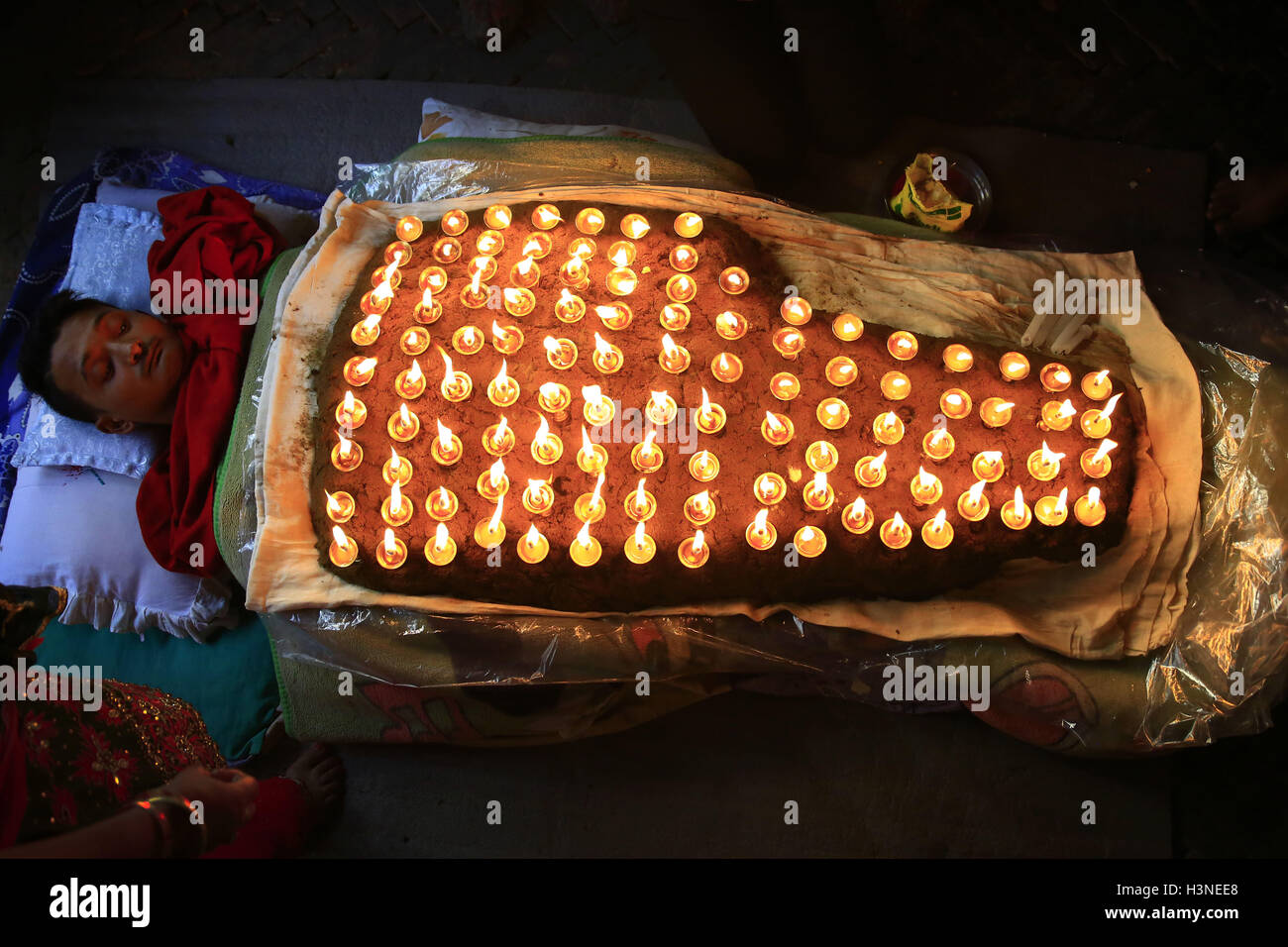 Bhaktapur, Nepal. Undicesimo oct, 2016. Un devoto nepalese è coperto con illumina di lampade ad olio sul suo corpo mentre offrendo preghiere durante la Durga Puja, che cade il decimo giorno di quindici giorni, lungo l induismo il più grande festival religioso di Dashain in Bhaktapur, Nepal Martedì, 11 ottobre 2016. Dashain è la più lunga e la più promettente festival nel calendario nepalese, celebrata in tutta la nazione e il mondo dal popolo nepalese. © Skanda Gautam/ZUMA filo/Alamy Live News Foto Stock