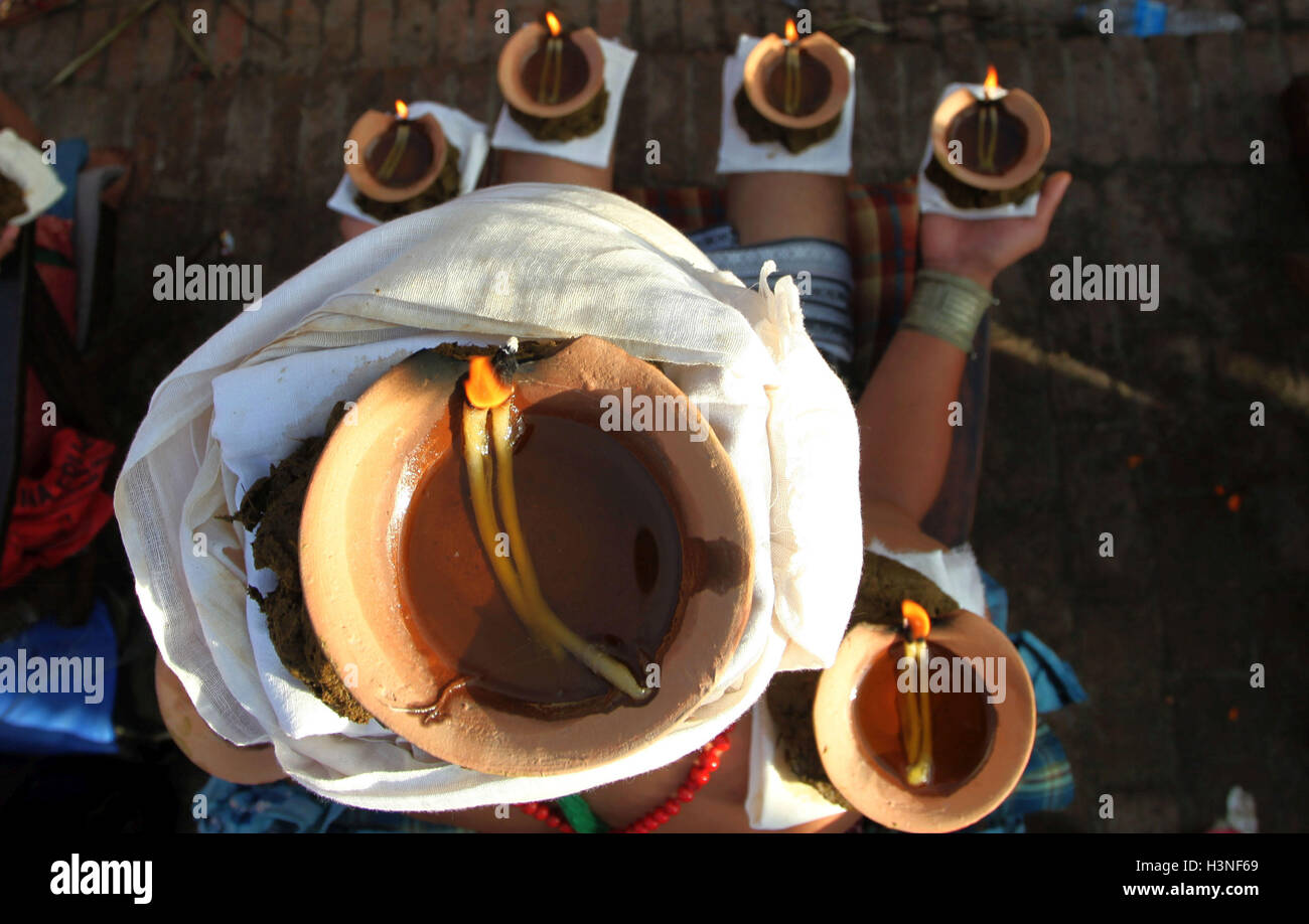 Bhaktapur, Nepal. Undicesimo oct, 2016. Un devoto si siede con illuminato lampada olio sulla testa e palme mentre offrendo preghiere durante il Dashami, il decimo giorno del Hindu il religioso più 'Dashain'' festival di Bhaktapur, Nepal © Sunil Sharma/ZUMA filo/Alamy Live News Foto Stock