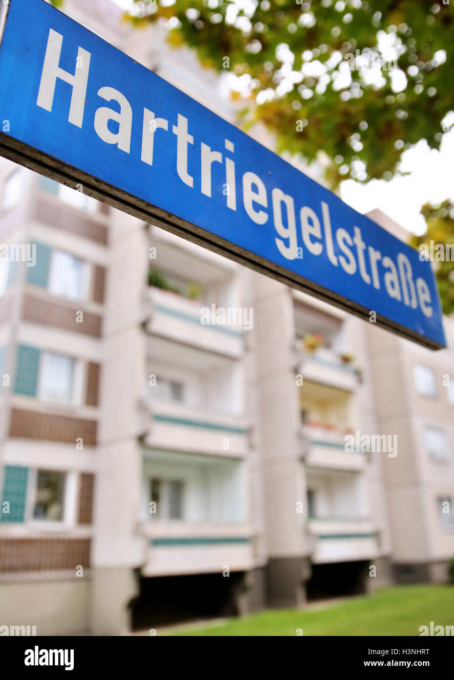 L'edificio residenziale in cui il fuggitivo sospetta terrorista Jaber al-Bakr stato arrestato il 10 ottobre 2016 è visto dietro il cartello stradale a Leipzig, Germania, 11 ottobre 2016. Il 22-anno-vecchio al-Bakr fu preso dal compagno di rifugiati siriani e consegnato alla polizia di lunedì sera. Foto: Jan Woitas/dpa Foto Stock