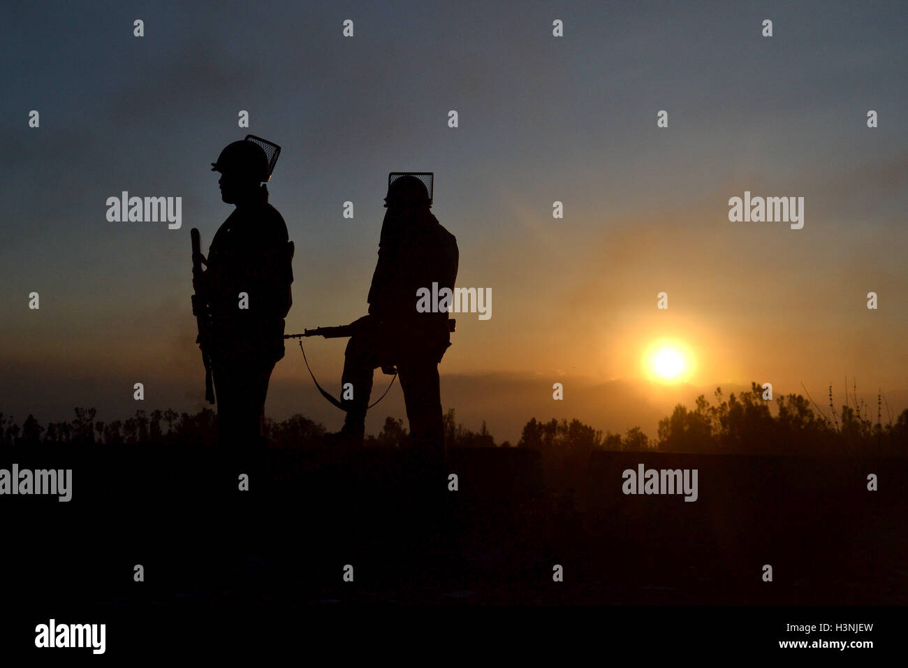 Srinagar Kashmir. 11 ottobre, 2016. Il personale militare sostare vicino edificio EDI presi in consegna da sospetti militanti durante gli scontri. Credito: Saqib Majeed/Alamy Live News Foto Stock